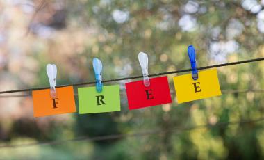 word-free-spelled-colorful-papers-hanging-rope-attached-by-clothes-peg-outside-green-nature