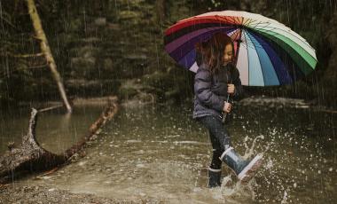 little-girl-using-umbrella-stream-rainy-day