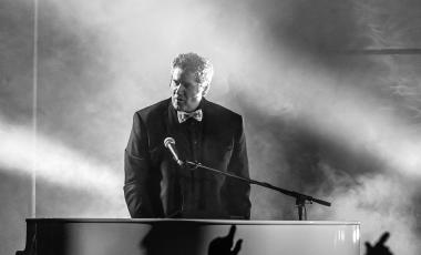 a man plays piano in a smoky moody bar