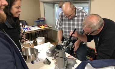 volunteer fixers repairing a mixer