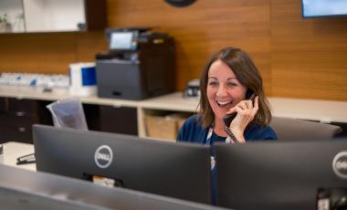 Front counter customer experience staff helping a client on the phone