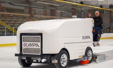 staff driving zamboni ice resurfacing machine at arena