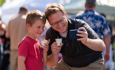 adult and child taking photo at chili fest 