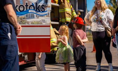 Young kids looking up at an Okotoks fire engine during Fire Prevention Week