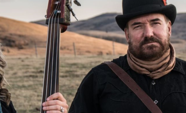 two members of Over the Moon stand in a field 