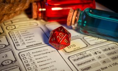 Close-up of a red d20 on a character sheet