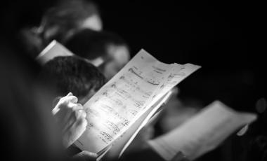 Hand holding music score in choir