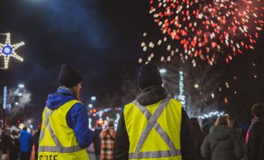 staff standing in front of fireworks