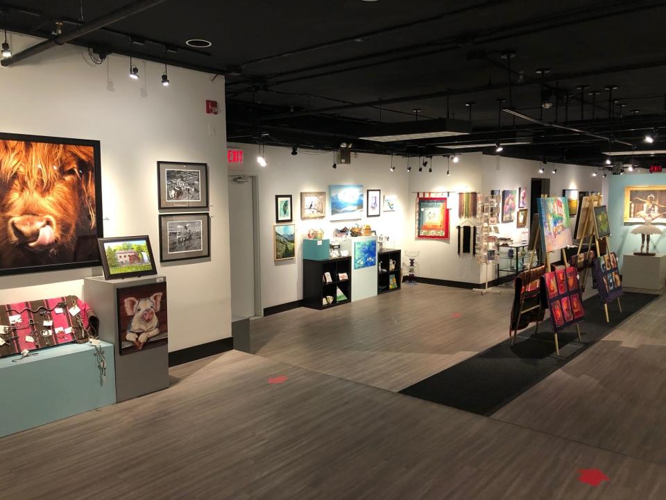 Wide view of the inside of the Art Gallery with many paintings on the wall.