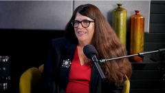 CAO Elaine Vincent smiling in front of podcast mic