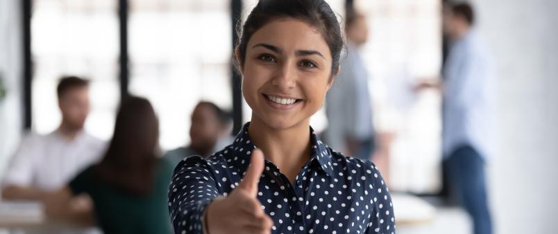 friendly woman stretching out hand to welcome someone to work in a recruitment job hiring setting