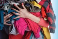 Woman's hands full of clothing to donate or swap