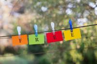 word-free-spelled-colorful-papers-hanging-rope-attached-by-clothes-peg-outside-green-nature