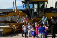 Children standing in front of the grader