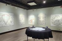 Colouring sheets hung on walls in small gallery