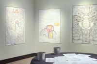 Colouring sheets hung on walls in small gallery