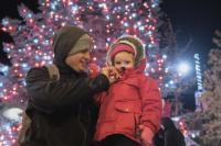 two people stand in front of a light tree