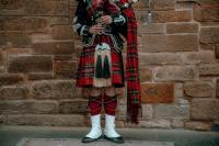 male-wearing-traditional-scottish-kilt-standing-front-wall