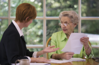 Woman helping senior lady with paperwork