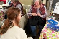 Volunteer fixer repairing clothing item