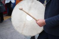 a man hits an old drum with a beater