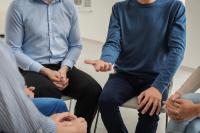 a group of men sit in a circle 