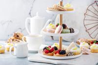 a setting for high tea with baked goods and cups