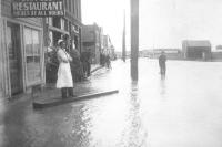 a woman stands on a flooded street