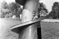 Small children play on a spiral metal slide.