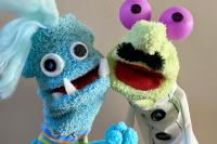 Two hand and rod puppets with big googly eyes and fangs.