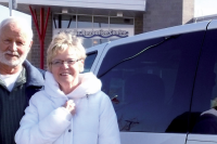 two volunteers drivers stand next to a van