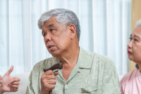 A health practitioner speaks to two seniors