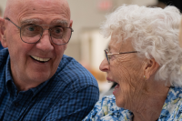 A group of seniors is seen chatting and laughing with one another