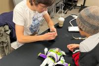 Repair Cafe volunteer helping fix a stuffed toy for a child