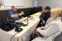 A fixer helps a couple repair a lamp