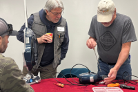 Two men repair a vaccum at a Repair Cafe