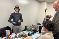 A fixer helps two community members at a Repair Cafe