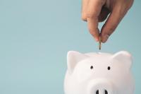 coin to white piggy bank saving