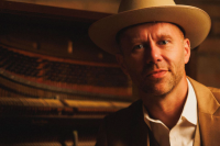 Jeffery Straker in front of a piano