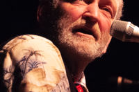 valdy singing on a stage