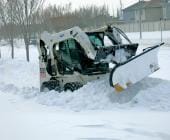 Bobcat clearing snow from pathway