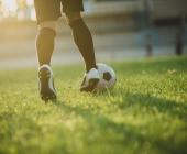 soccer player's feet dribbling ball on a playing field