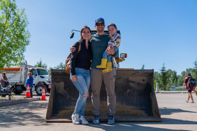 a family poses in front of a front loader 