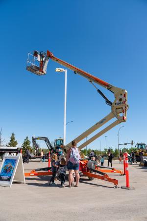 a crane extends with familes watching 
