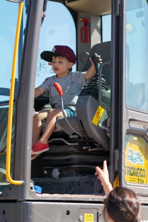 a kid plays with levers inside of a construction loader