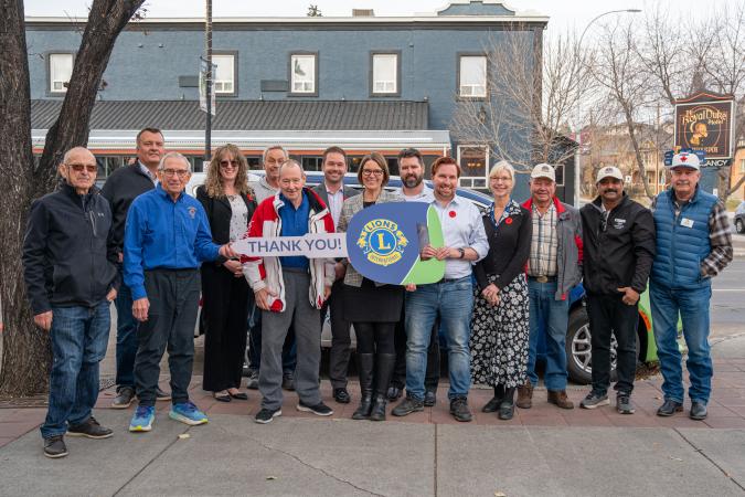 Okotoks transit van donation with members of Council and the Okotoks Lions Club standing in front of van with large key