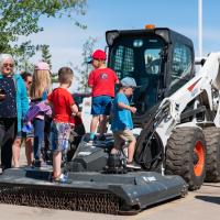 families looking at a construction bobcat