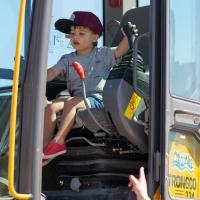a kid plays with levers inside of a construction loader