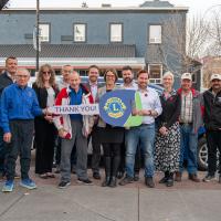 Okotoks transit van donation with members of Council and the Okotoks Lions Club standing in front of van with large key