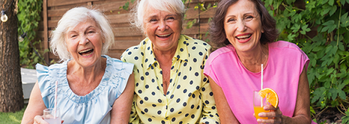 three senior women laughing in garden